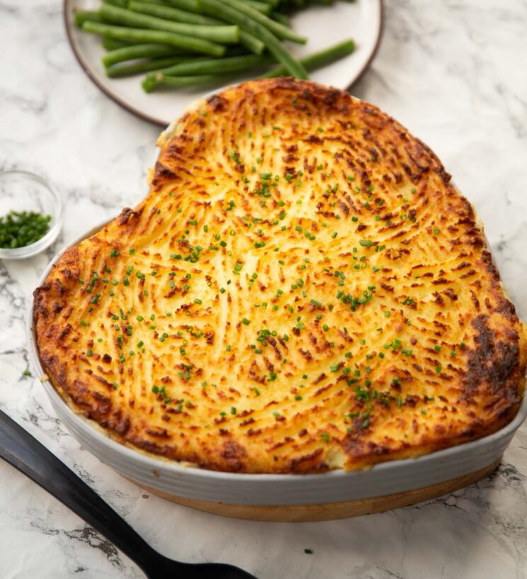 classic fish pie classic fish pie served in heart shaped baking dish with green beans in background