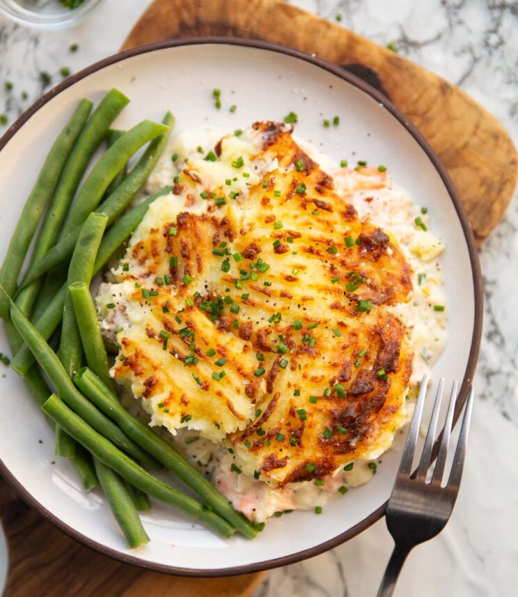 fish pie overhead shot of fish pie served on small white plate with green beans