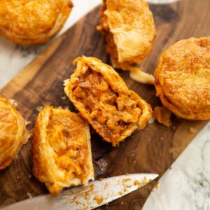overhead close up shot of chicken and chorizo pies on chopping board