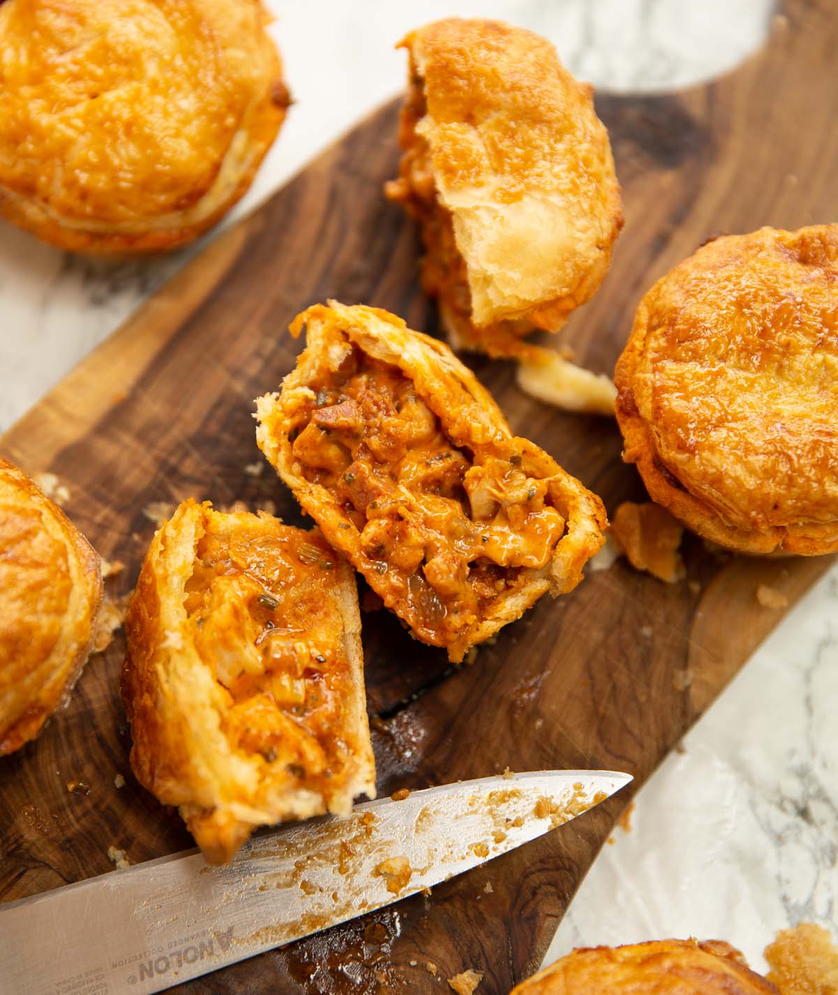 overhead close up shot of chicken and chorizo pies on chopping board
